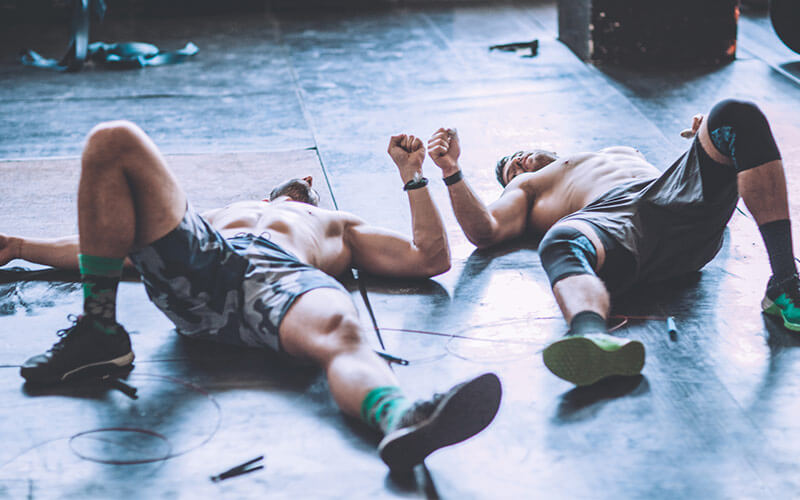 Due uomini esausti a terra dopo l'allenamento