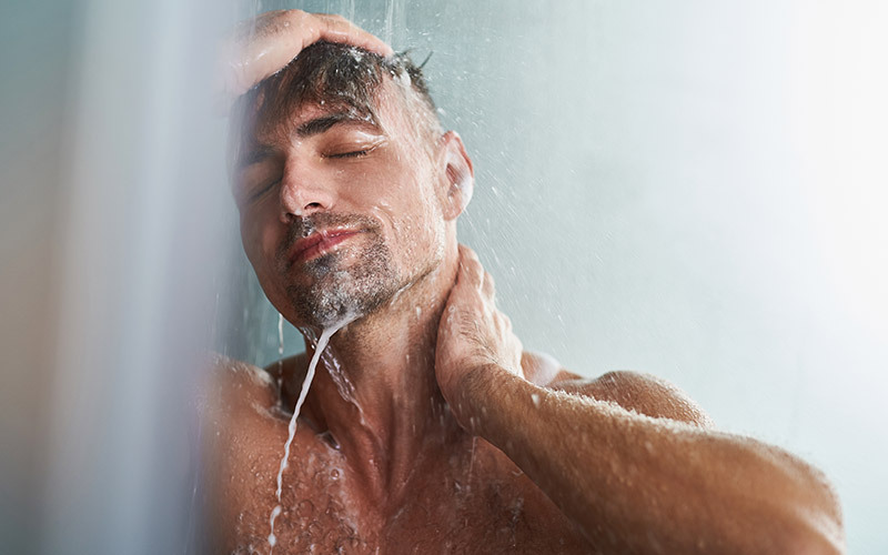 Uomo si fa una doccia calda dopo l'allenamento