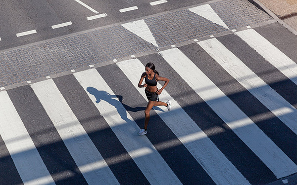 donna che fa jogging sulle strisce pedonali