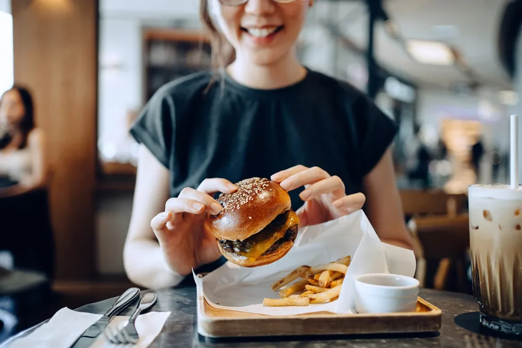 Una ragazza mangia un hamburger