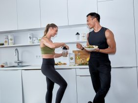 Mann und Frau stehen in der Küche und essen
