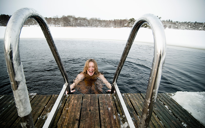 Frau steigt in einen fast zugefrorenen See