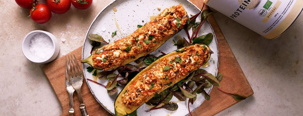 two halves of a stuffed zucchini filled with bright toppings
