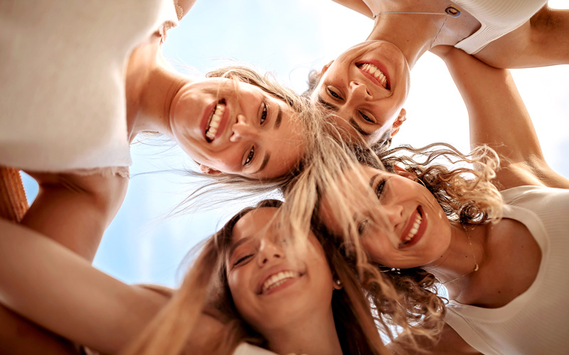 4 Frauen bilden einen Kreis und schauen von oben in die Kamera