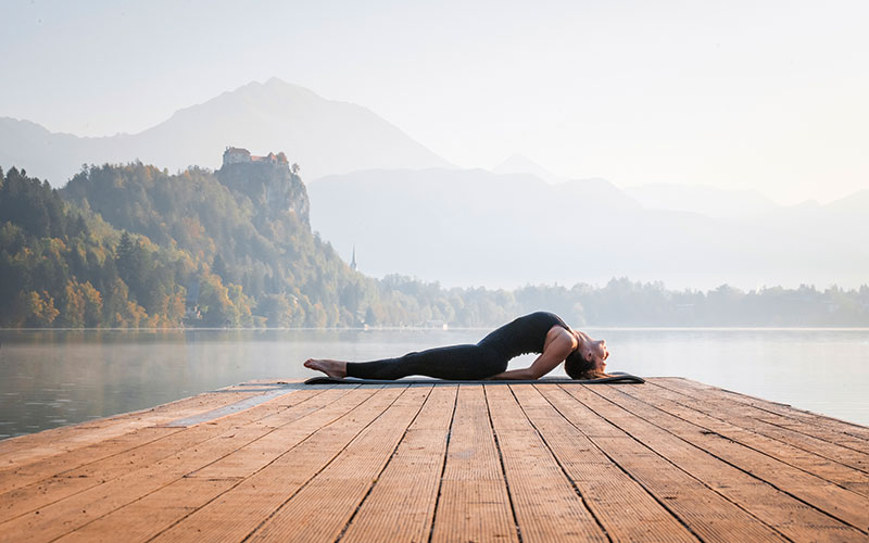 femme pratiquant la posture du poisson près d'un lac