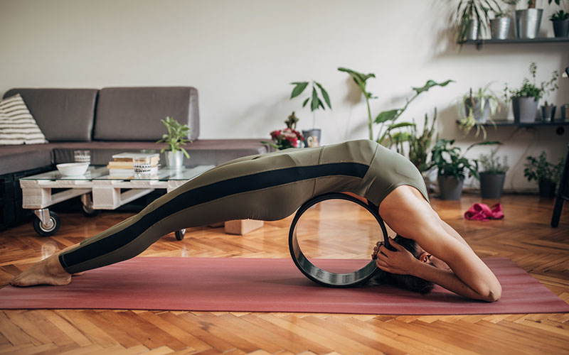 Eine Frau praktiziert Yoga mit dem Rad