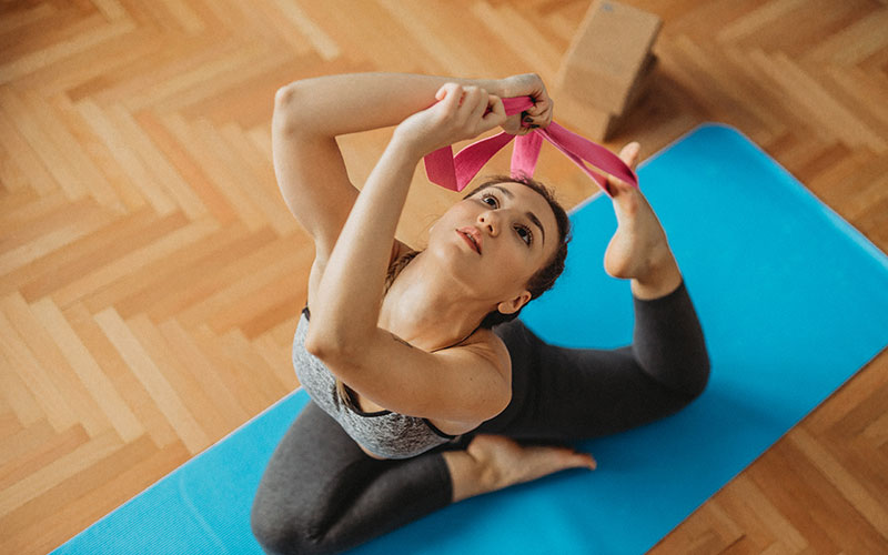Eine Frau macht Yoga mit einem Gurt