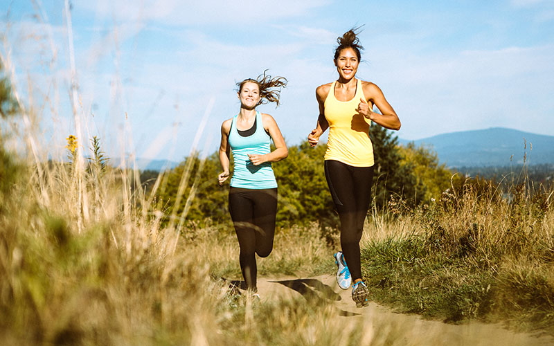 2 Frauen joggen über die Felder