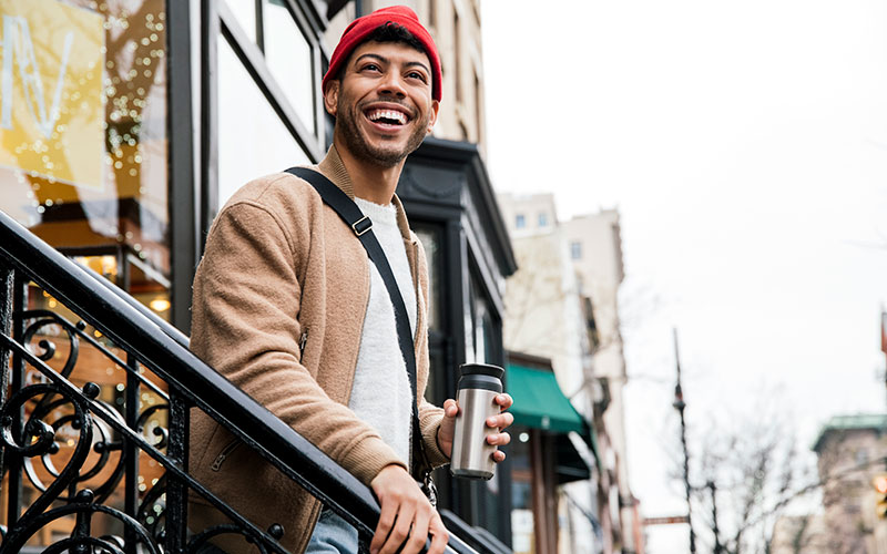 homme souriant avec un café dans la main