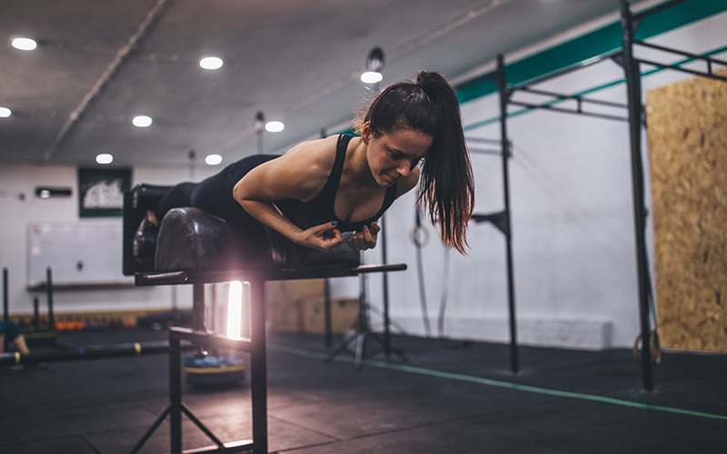 Eine Frau macht Hyperextensions im Gym