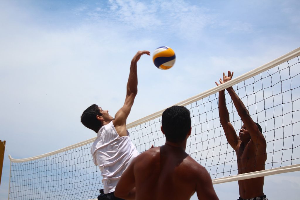 Eine Gruppe von Männern spielt draußen Volleyball