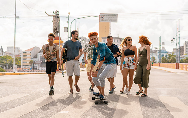 Un uomo va in skateboard mentre un gruppo di persone cammina dietro di lui