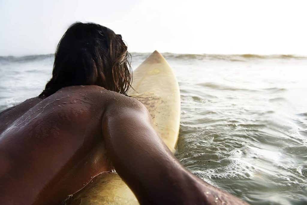 Surfare - Uomo che pagaia su una tavola da surf