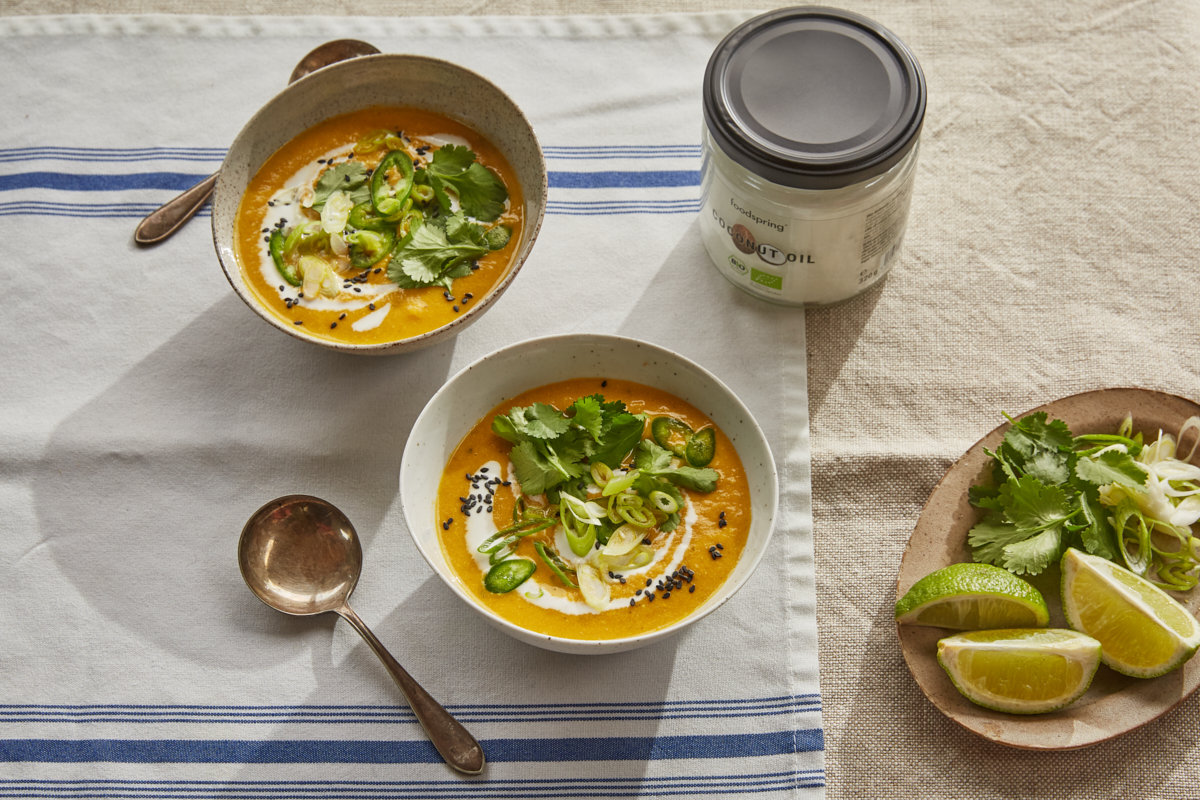 bowls of carrot ginger and lemongrass soup with coriander and lime
