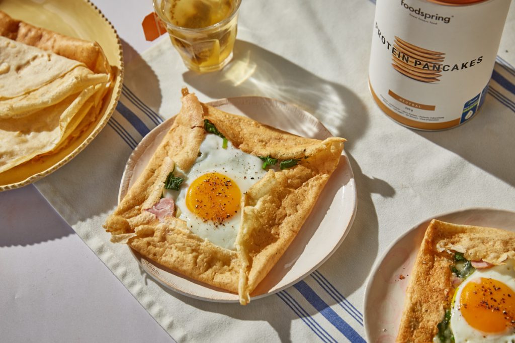 a galette crepe filled with egg, spinach and ham with a cup of tea