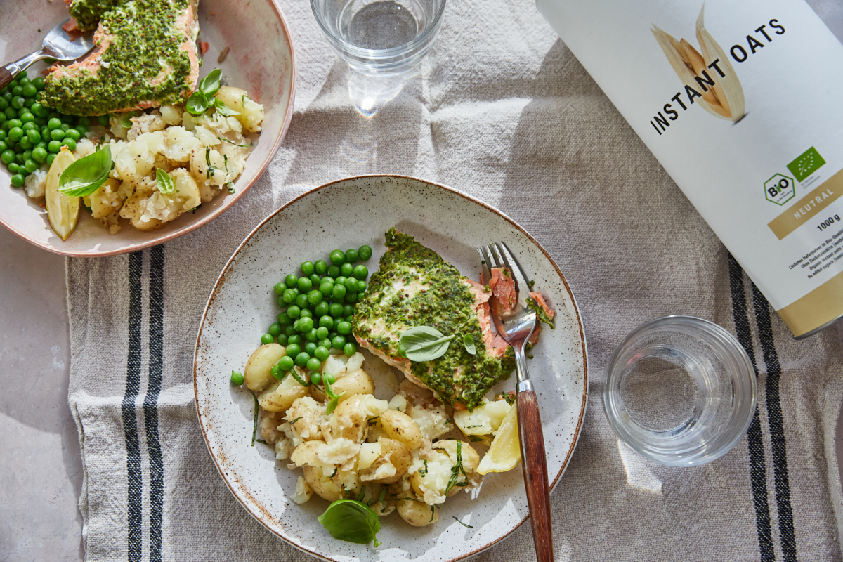 two bowls of parsley crusted salmon with crushed new potatoes and peas