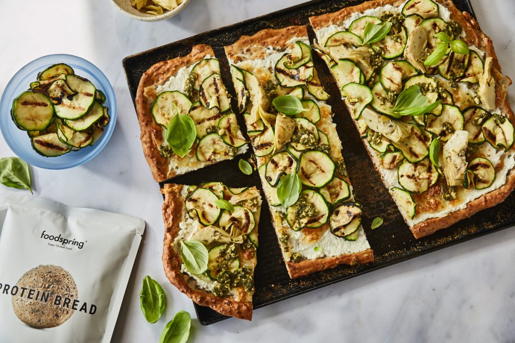 courgette flatbread with ricotta and artichokes on a tray