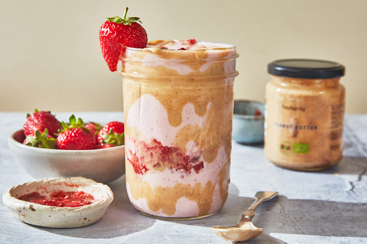 peanut butter strawberry smoothie in a mason jar swirled with peanut butter
