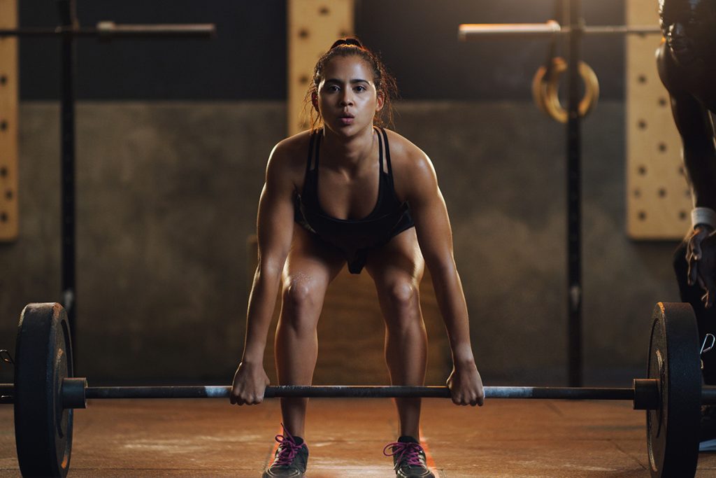 ejercicios para el desarrollo muscular - Una mujer hace deadlifts