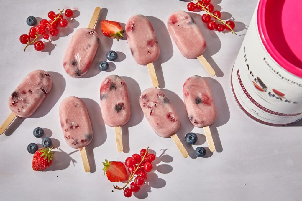 ghiaccioli shape shake allo yogurt e frutti di bosco appoggiati su un tavolo di marmo