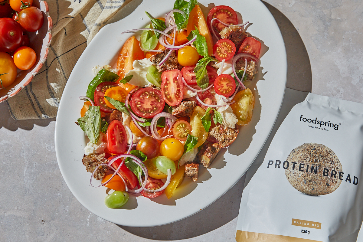 high protein healthy panzanella salad on a white oval plate