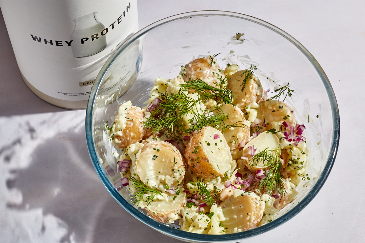 higher protein healthy potato salad in a glass mixing bowl