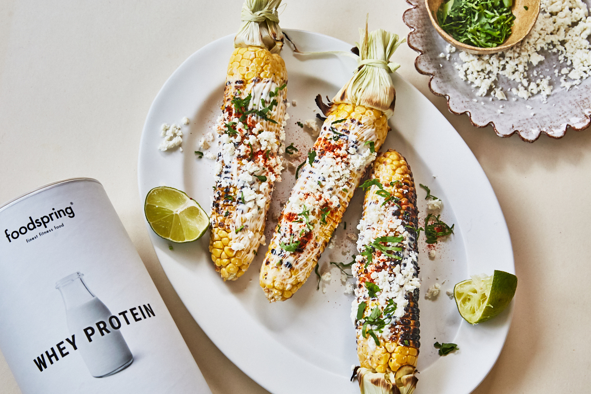 Mexican street corn on a plate with coriander and cheese