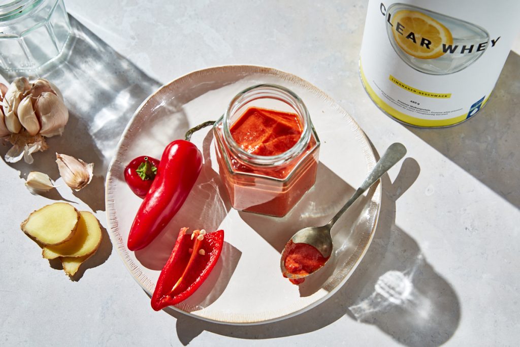 salsa al peperoncino dolce - salsa al peperoncino dolce in barattolo con accanto peperoncino fresco, zenzero e aglio