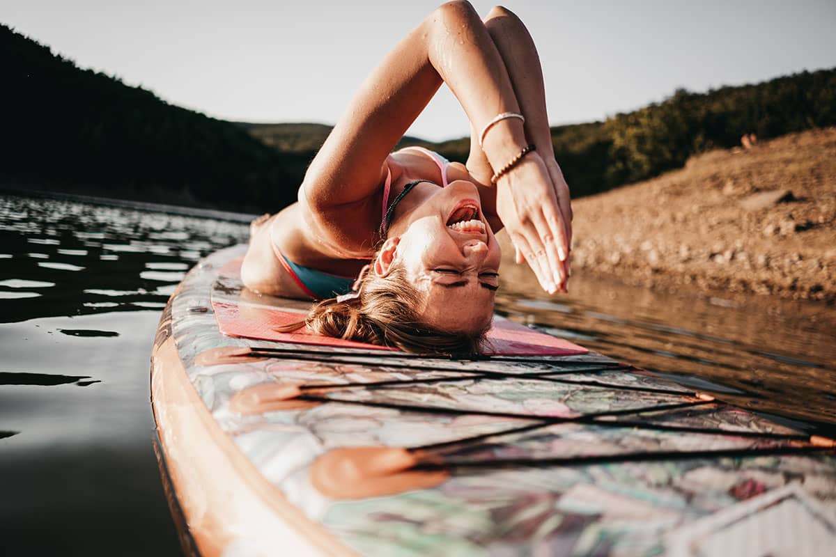 Frau macht Yoga auf Stand Up Paddle