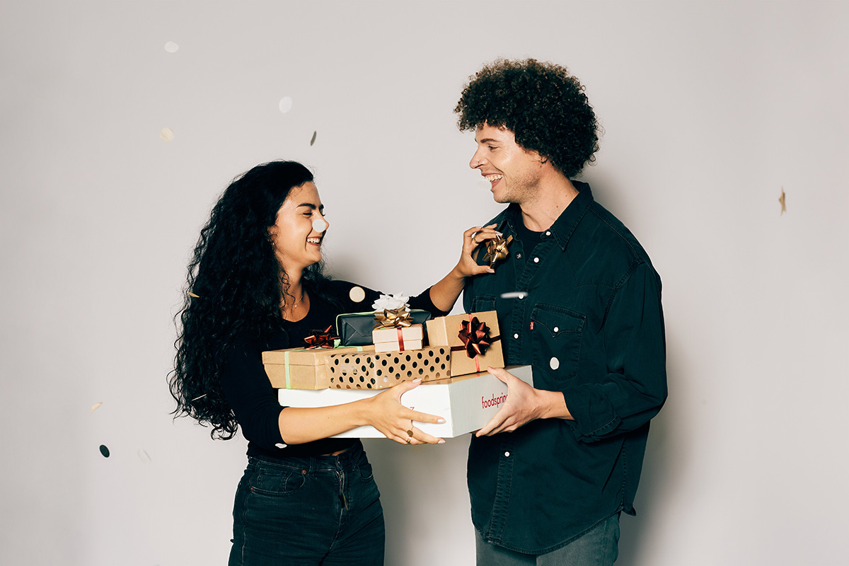 zwei personen halten weihnachtliche geschenke und aventskalender